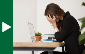 Seated person with their face in their hands