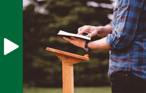 Person with their hands cupping their face while sitting at a desk in front of a computer