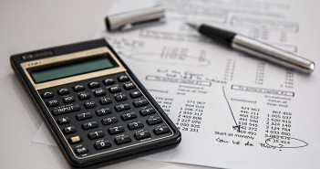 Stock photo of a calculator on top of a monthly expenditure report