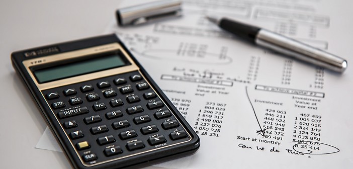 Stock photo of a calculator on top of a monthly expenditure report