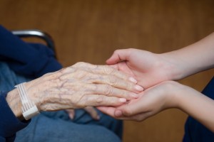 Stock photo of an older person's hand in the hands of a younger person