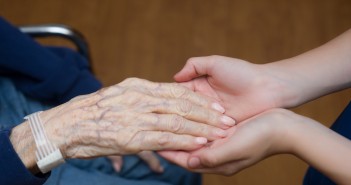 Stock photo of an older person's hand in the hands of a younger person