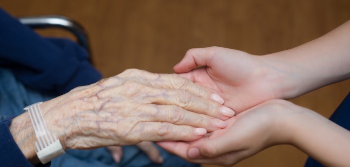 Stock photo of an older person's hand in the hands of a younger person