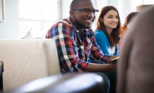Stock photo of a young African American man and a young white woman in a fellowship group