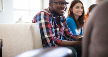 Stock photo of a young African American man and a young white woman in a fellowship group