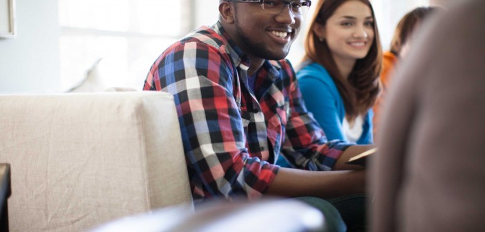 Stock photo of a young African American man and a young white woman in a fellowship group