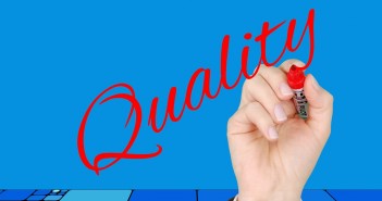 Stock photo of a hand writing "Quality" in a cursive script