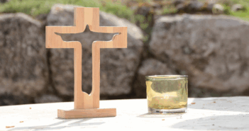 What Leaders Need to Know about the Emerging Church Wooden cross and a candle atop a table