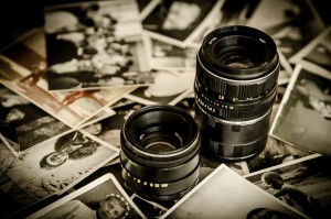 Stock photo of two DSLR camera lenses among a pile of black-and-white photos