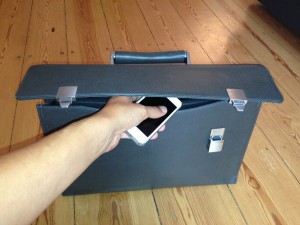 Stock photo of an individual putting an iPhone in a briefcase
