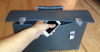 Stock photo of an individual putting an iPhone in a briefcase