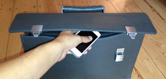 Stock photo of an individual putting an iPhone in a briefcase