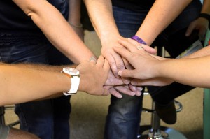 Stock art of a group of hands in the middle of a huddle