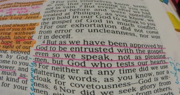 Stock photo of a heavily annotated and highlighted bible opened up to 1 Thessalonians with chapter 2, verse 4 underlined in pink