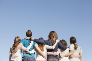 Stock photo of the backs of a white family - mom, dad, and four daughters - looking up at the sky