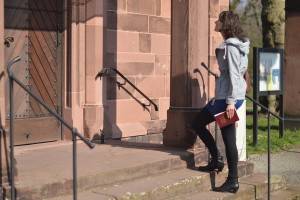Stock photo of a young white woman going into a big church