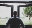 Stock photo of a white man facing an open window