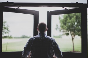 Stock photo of a white man facing an open window