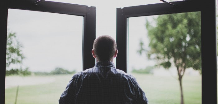 Stock photo of a white man facing an open window