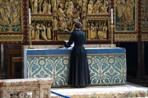 Stock photo of a clergywoman at an altar preparing for services