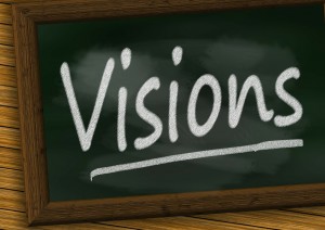 The word VISIONS written in chalk on a blackboard