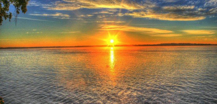 Stock photo of the sun rising or setting over a lake