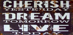 Stock photo of a rustic motivational item that says "CHERISH YESTERDAY DREAM TOMORROW LIVE TODAY"