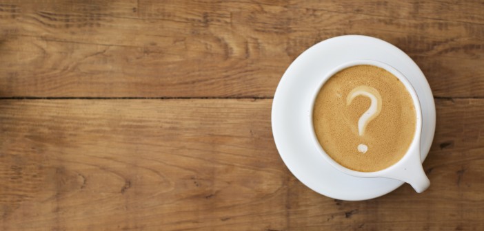 Stock photo of a latte in which the foam art is a question mark