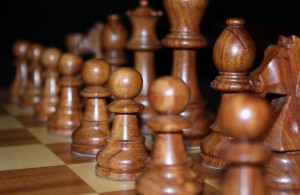 Closeup stock photo of a set of black chess pieces carved out of wood