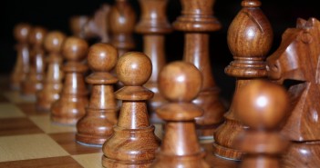 Closeup stock photo of a set of black chess pieces carved out of wood