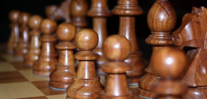 Closeup stock photo of a set of black chess pieces carved out of wood