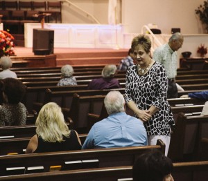 Stock photo of older white people talking to each other before church starts