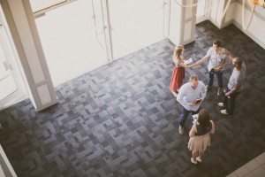 Stock photo of a welcoming area of a building taken from above and looking down into a group of people welcoming others