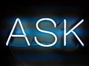 Stock photo of an illuminated neon sign that says "ASK"