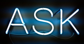 Stock photo of an illuminated neon sign that says "ASK"