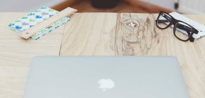 Stock photo of an Apple laptop on a wooden table