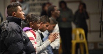 A stock photo of a diverse group of people praying