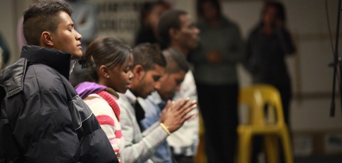A stock photo of a diverse group of people praying