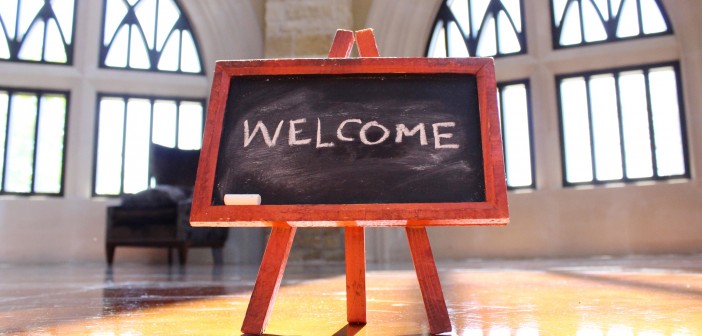 Stock photo of a small chalkboard in the middle of a room that has "WELCOME" written on it