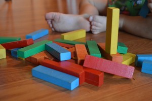 Stock photo of a baby playing with multi-colored blocks