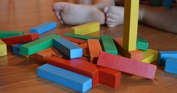 Stock photo of a baby playing with multi-colored blocks