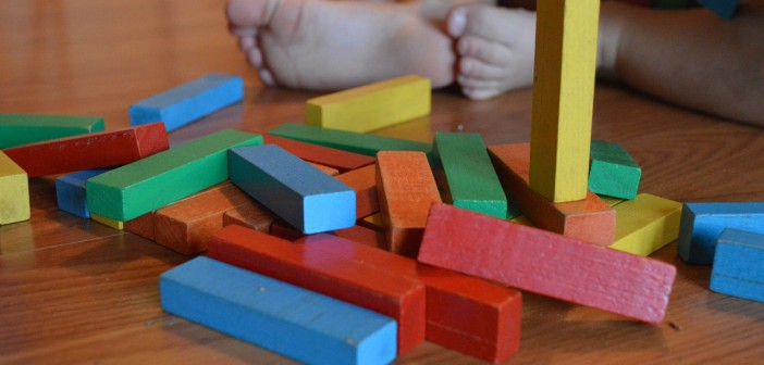 Stock photo of a baby playing with multi-colored blocks