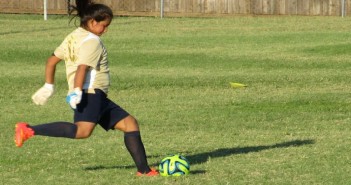 Stock photo of a young woman about to kick a soccer ball