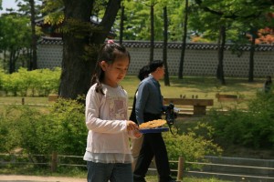 Stock photo of an Asian girl playing with bubbles in a park
