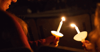Passing the flame from candle to candle during a Travelers' Christmas Eve service