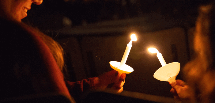 Passing the flame from candle to candle during a Travelers' Christmas Eve service