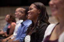 Stock photo of a diverse group of young people smiling in an audience