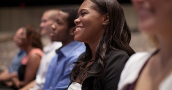 Stock photo of a diverse group of young people smiling in an audience