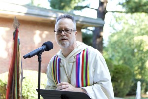 Photo of an older white clergyman preaching outside at Wesley Theological Seminary