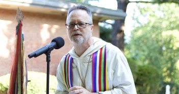 Photo of an older white clergyman preaching outside at Wesley Theological Seminary